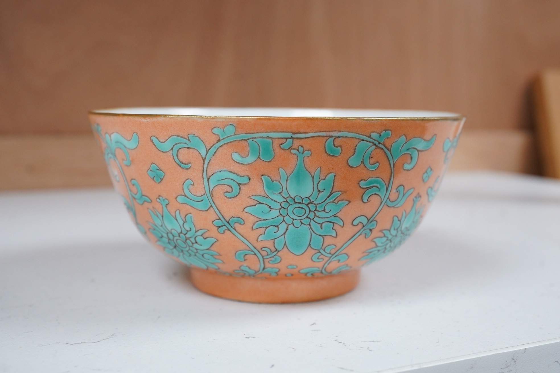 A Chinese pale coral ground ‘lotus’ bowl, Tongzhi mark and period, 12cm diameter. Condition - good